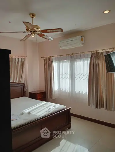 Cozy bedroom with natural light, ceiling fan, and air conditioning unit