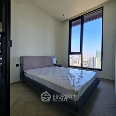 Modern bedroom with large window offering stunning city view