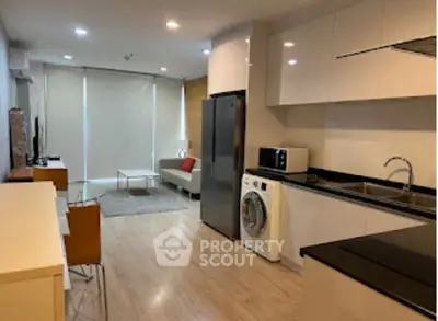 Modern open-plan kitchen and living room with sleek appliances and stylish decor.