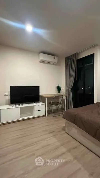 Modern bedroom with TV, air conditioning, and cozy decor in a stylish apartment.