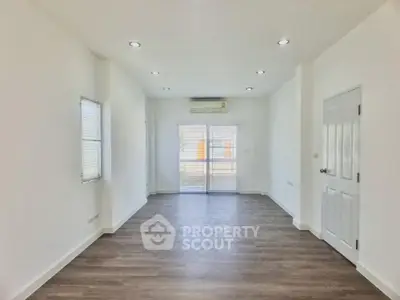 Spacious and bright living room with elegant hardwood flooring, recessed lighting, and a fresh, modern look, perfect for family gatherings.