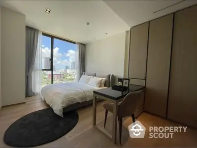 Spacious bedroom with large windows offering ample natural light and a stunning city view, featuring a cozy bed, modern furniture, and sleek wooden flooring.