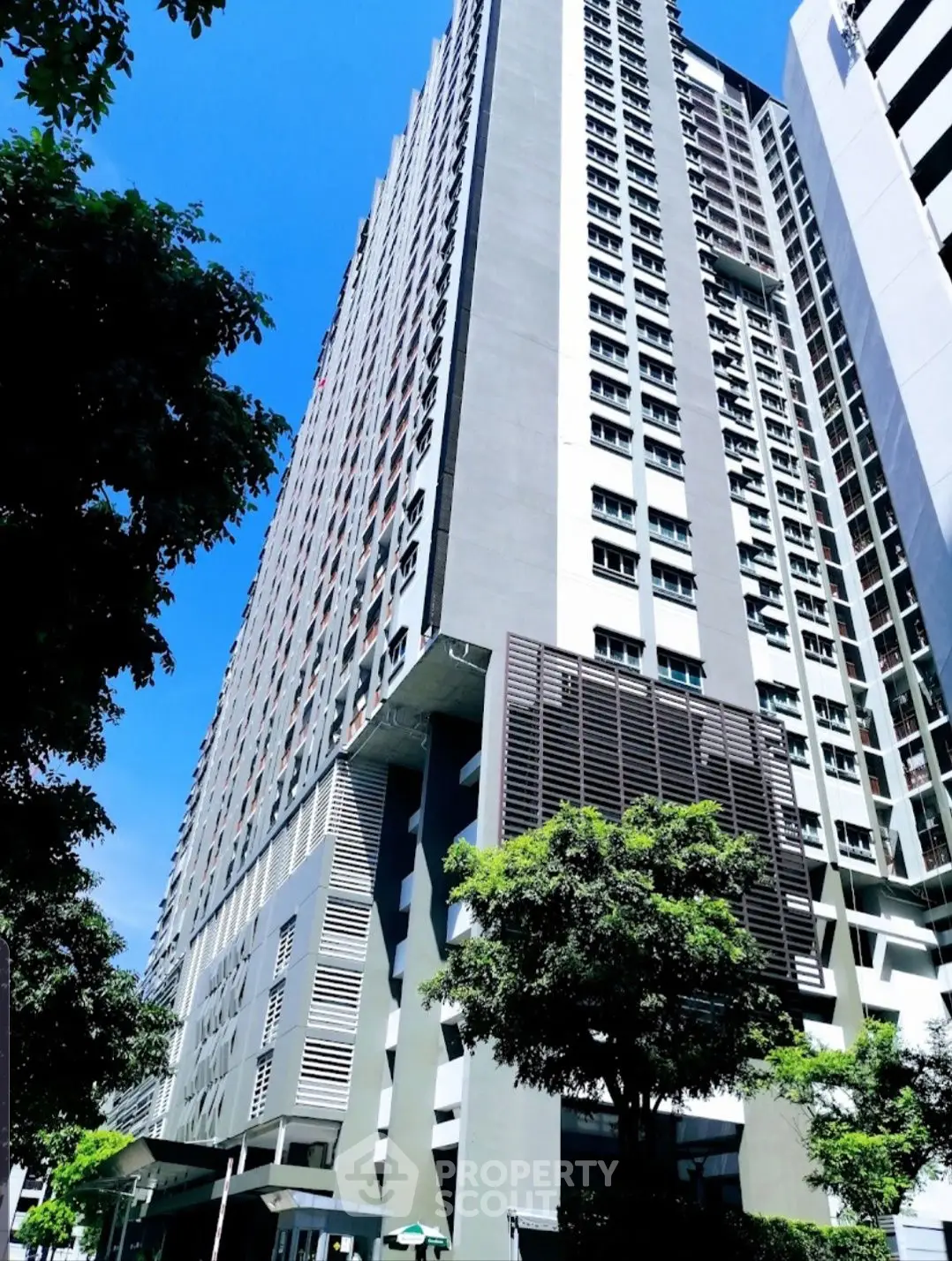 Stunning high-rise building with modern architecture and lush greenery, perfect for urban living.