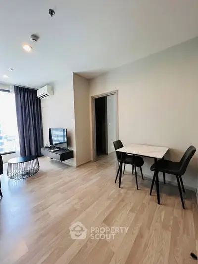 Modern living room with sleek furniture and wooden flooring in a bright apartment.