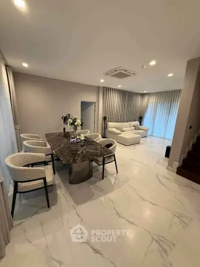 Luxurious open-plan living and dining area with elegant marble flooring and modern furnishings.