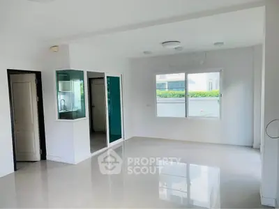 Spacious unfurnished room with large window and glossy floor, ideal for customization.