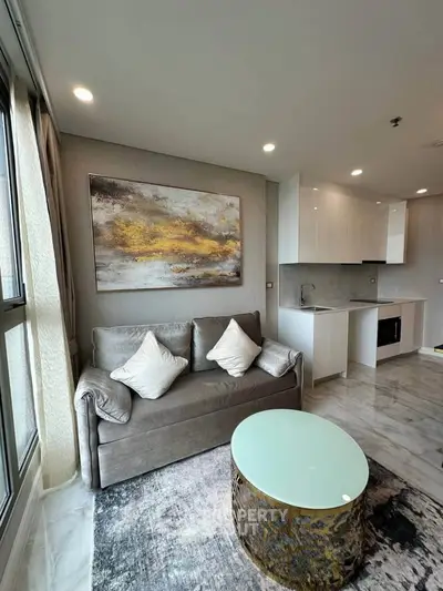 Modern living room with elegant decor, featuring a cozy sofa, stylish coffee table, and sleek open kitchen layout.