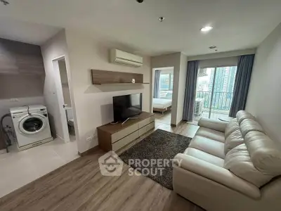 Modern living room with sleek furniture and city view, featuring a cozy sofa and wall-mounted TV.