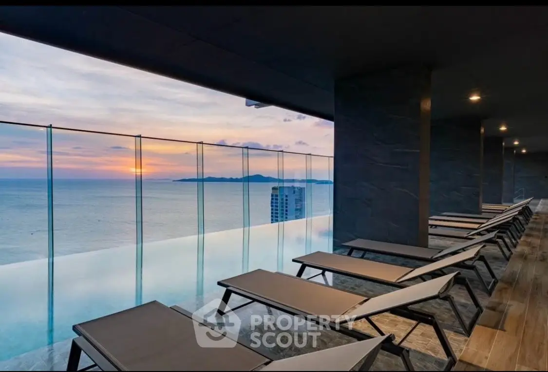 Luxurious rooftop pool with stunning ocean view at sunset, perfect for relaxation and leisure.
