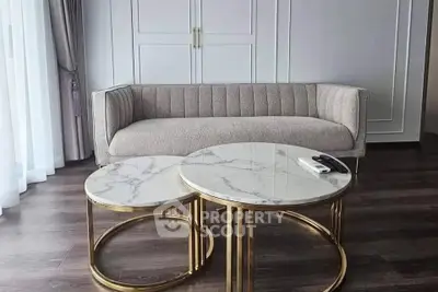 Elegant living room with modern sofa and marble coffee tables, perfect for stylish urban living.