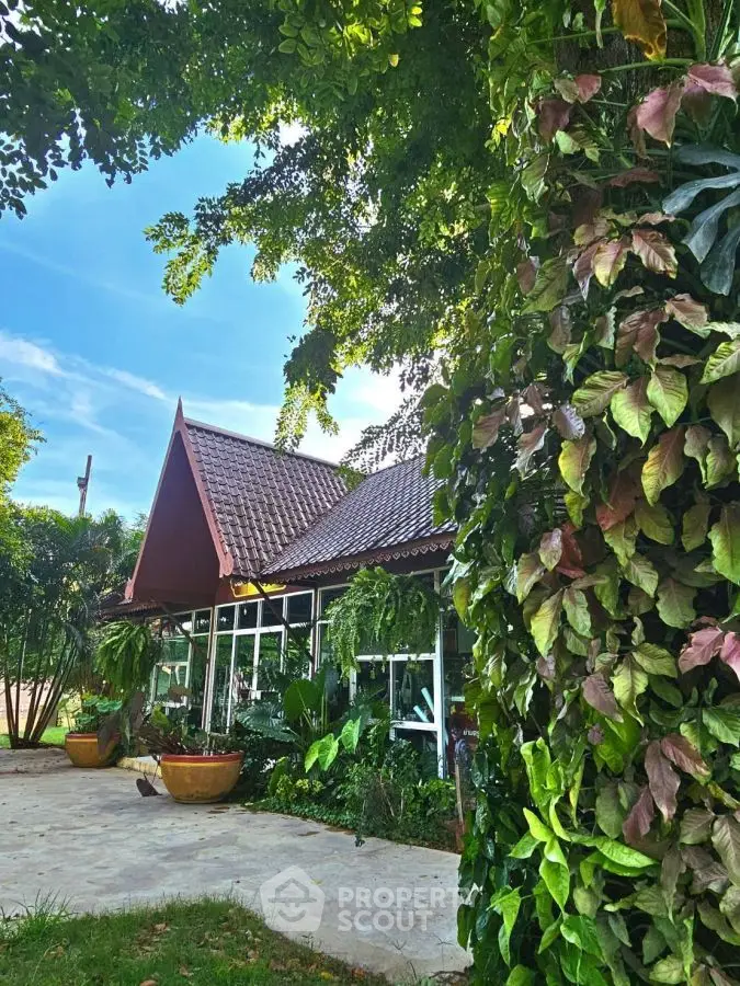 Charming tropical house with lush garden and unique roof design