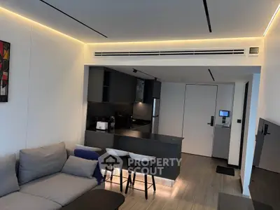 Modern open-layout living room with sleek kitchen and stylish lighting