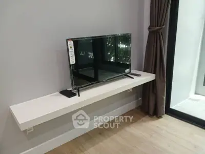 Modern living room with sleek TV setup and large window view