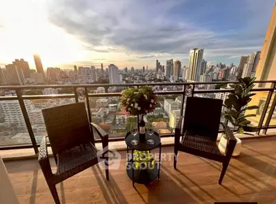 Stunning city view from a high-rise balcony with elegant seating, perfect for relaxation.