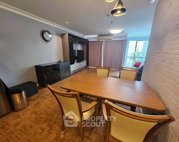 Spacious dining area with elegant wooden table and chairs, featuring modern lighting and parquet flooring.