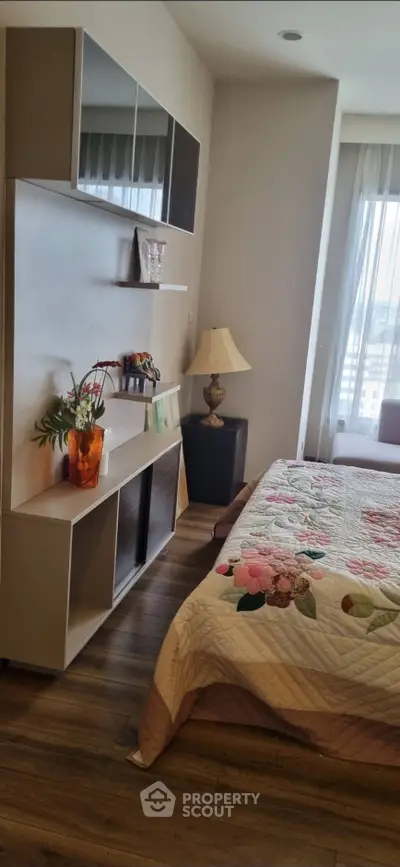 Cozy bedroom with floral bedding and modern shelving, perfect for relaxation and comfort.