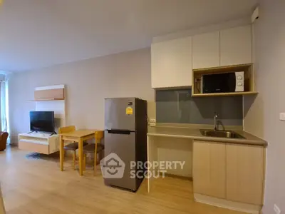 Modern apartment kitchen with open layout and dining area, featuring sleek appliances and contemporary design.