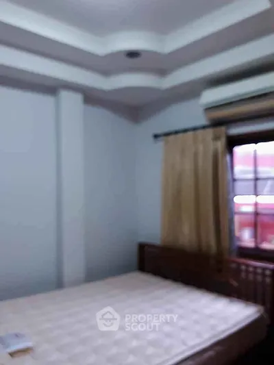 Cozy bedroom with natural light and modern ceiling design.