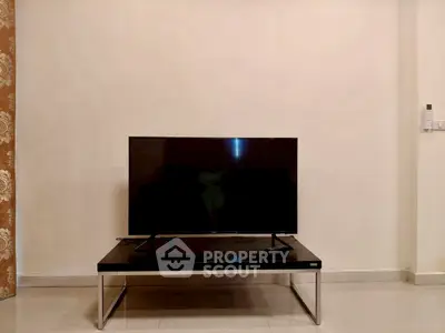 Minimalist living room with sleek TV setup on modern stand, perfect for entertainment enthusiasts.