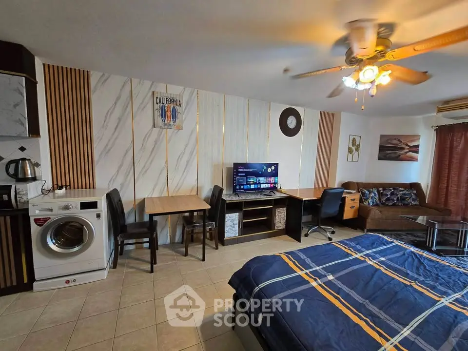 Spacious studio apartment with modern decor, featuring a washing machine and cozy living area.