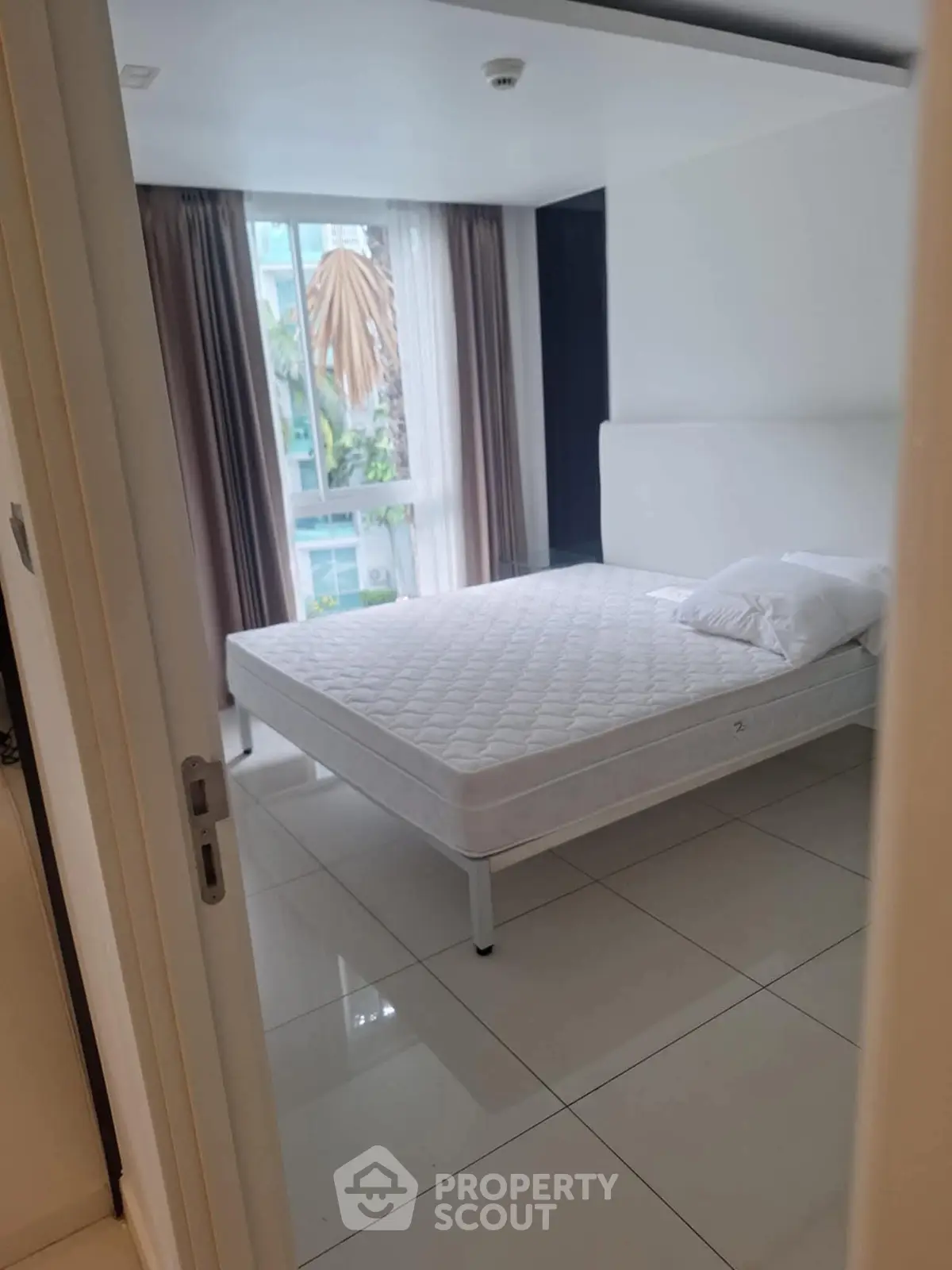 Bright bedroom with large window and minimalist decor in modern apartment.