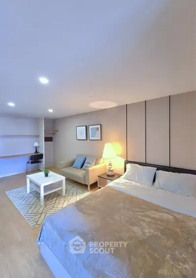 Spacious bedroom with cozy seating area and modern decor