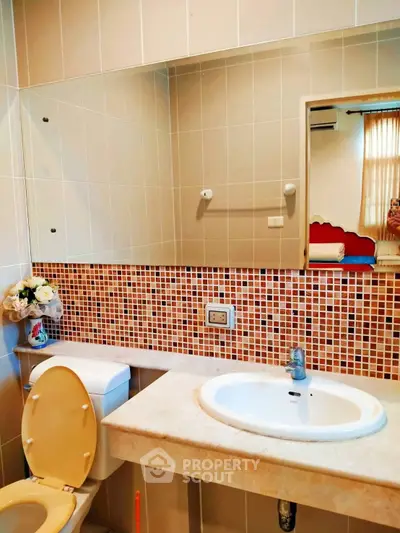 Charming bathroom with elegant mosaic tiles and modern fixtures.