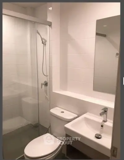Modern bathroom with glass shower and sleek fixtures in a contemporary apartment.