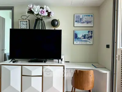 Modern living room with stylish decor, featuring a TV, elegant furniture, and wall art for a cozy ambiance.