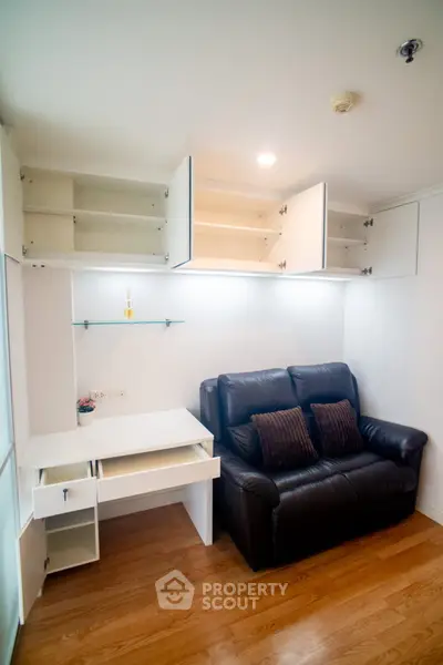 Cozy living room with leather sofa and built-in storage cabinets, perfect for modern living.