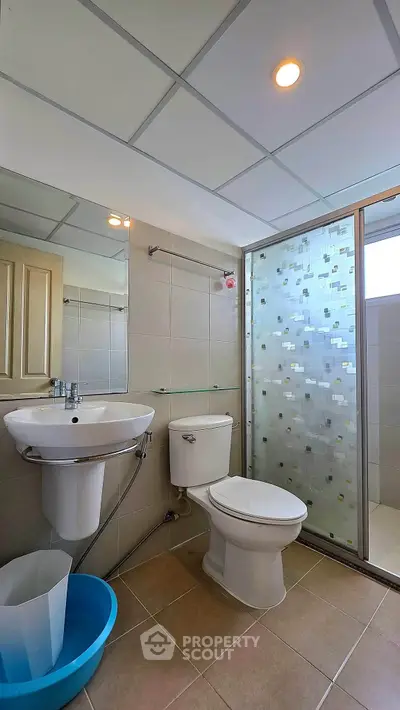 Modern bathroom with glass shower and sleek fixtures in a contemporary home.