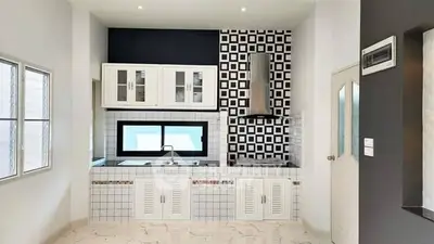 Modern kitchen with stylish black and white tile backsplash and sleek cabinetry.