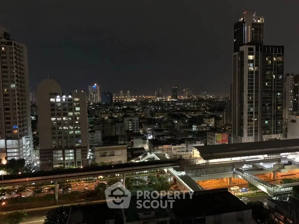 Stunning cityscape view from a high-rise building at night, showcasing urban skyline and vibrant city lights.