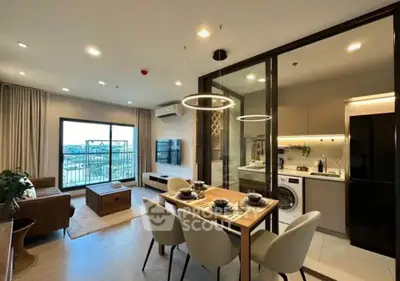 Modern open-plan living room and kitchen with stylish dining area and balcony view.
