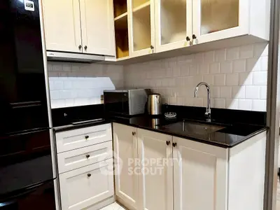 Modern kitchen with sleek black countertops and white cabinetry