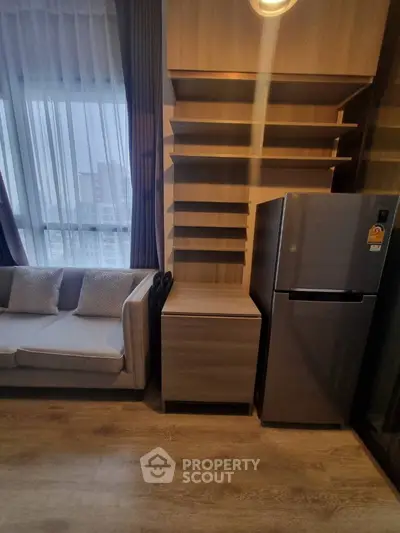 Modern living room with sleek shelving and stainless steel fridge