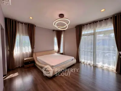 Spacious bedroom with modern lighting and large windows in a luxury home