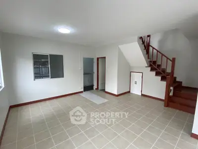 Spacious living room with staircase and tiled flooring in modern home