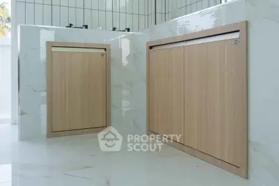 Modern kitchen with sleek wooden cabinetry and marble flooring
