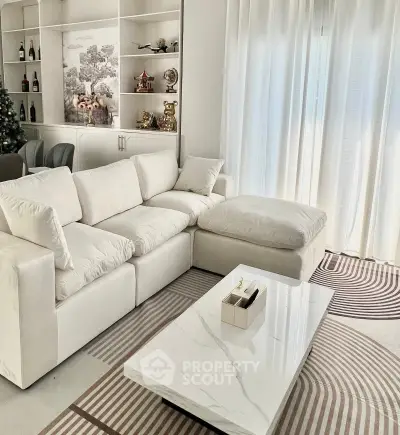 Elegant living room with plush white sofa and modern marble coffee table, perfect for stylish relaxation.