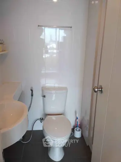 Modern bathroom with sleek fixtures and minimalist design, featuring a compact layout and contemporary style.