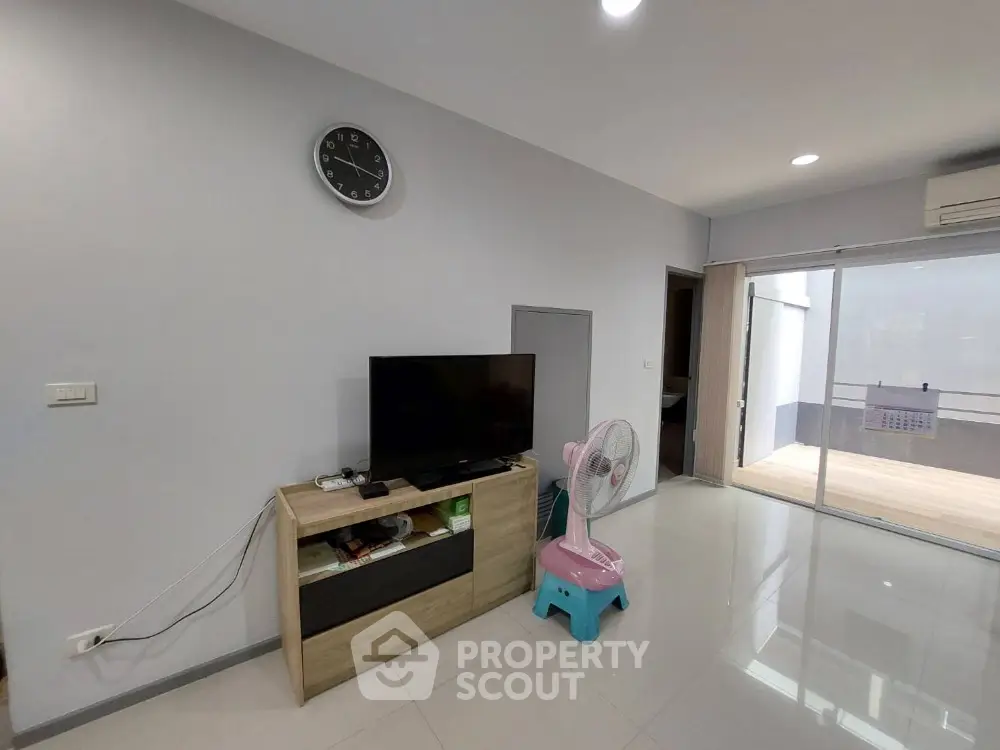 Modern living room with sleek TV setup and balcony access