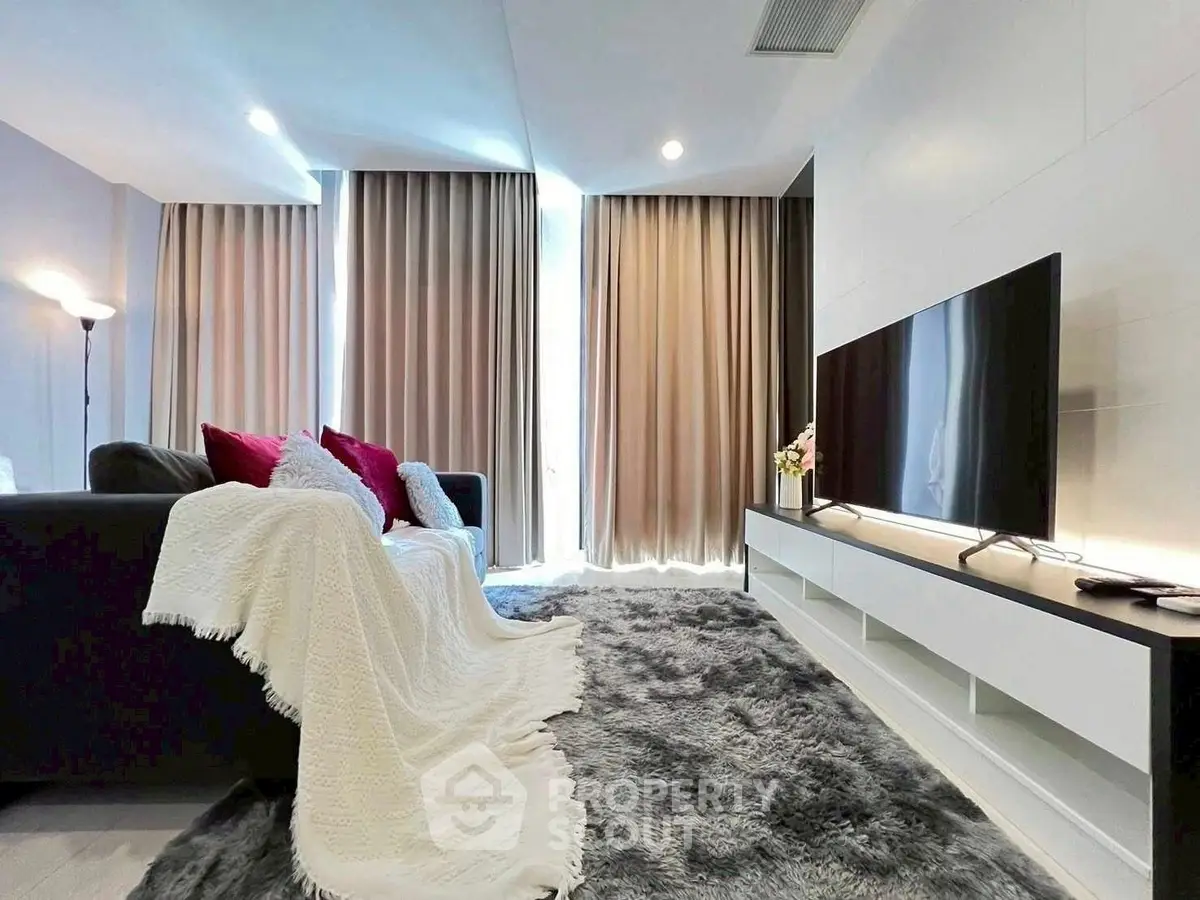 Luxurious living room with plush carpet and modern TV setup