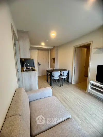 Modern living room with open kitchen and dining area in a cozy apartment.