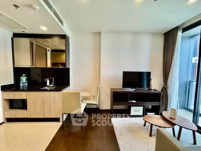 Modern living room with sleek furniture and open kitchen layout, featuring a cozy seating area and large windows.