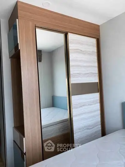 Modern bedroom with stylish wooden wardrobe and comfortable mattress.
