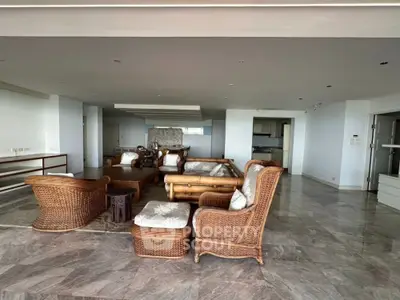 Spacious living room with elegant wicker furniture and marble flooring in modern apartment.
