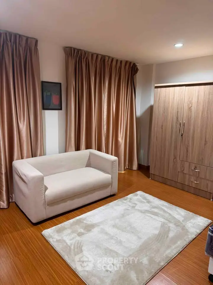 Cozy living room with modern sofa, elegant curtains, and wooden flooring for a warm ambiance.