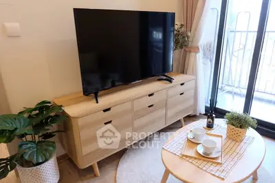Cozy living room with modern TV setup and balcony view
