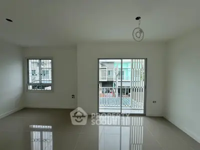 Spacious empty living room with large windows and glossy tiled floor